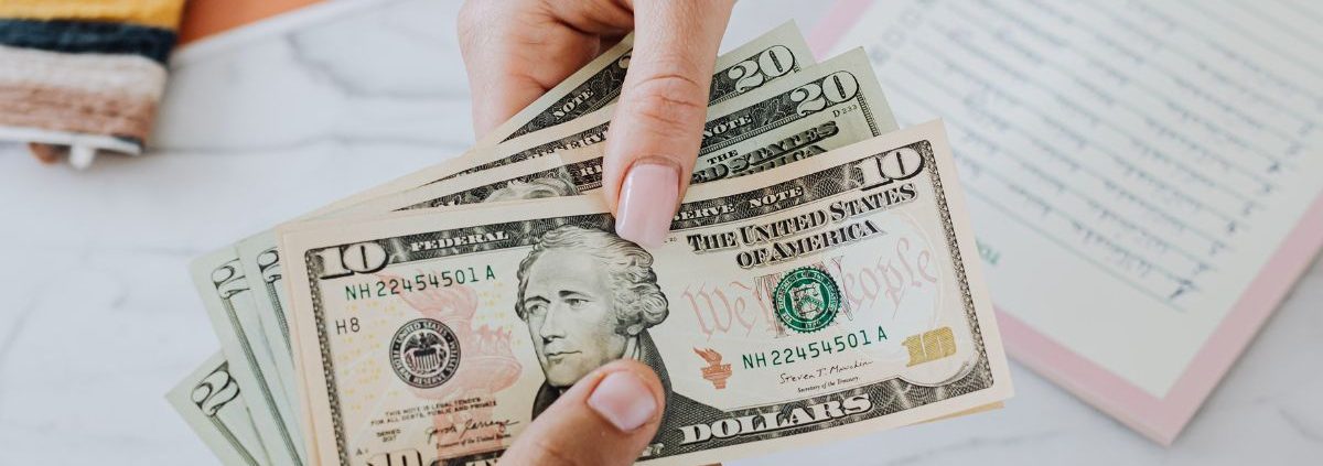 two hands exchanging American currency - Kyle's Kollectibles buying process